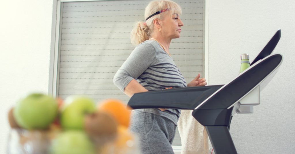 Elderly lady walking on the treadmill.